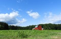 Red barn in crop field under blue sky in FingerLakes Royalty Free Stock Photo