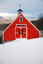 A red barn is decorated with a Christmas wreath