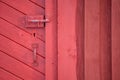 Red barn door with handle and key hole and deadbolt lock Royalty Free Stock Photo
