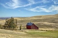 Red barn nestled within rolling hills