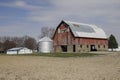 Red barn on a rural countryside farm, old, dilapidated and worn down. Former home of the local cows, horses and chickens Royalty Free Stock Photo