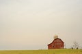 Red barn with silo off at a distance.