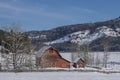 Red barn surrounded by barren trees