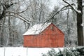 Red barn through the trees and snow Royalty Free Stock Photo