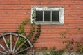 Red barn white window and wagon wheel Royalty Free Stock Photo