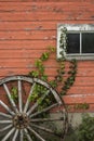 Red barn white window and wagon wheel Royalty Free Stock Photo