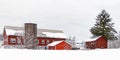 red barn with silo and evergreens in Winter white snow after snowstorm Royalty Free Stock Photo