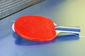 Red bat, tennis ball on blue ping pong table Royalty Free Stock Photo