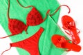 Red bathing suit and red flip-flops on green towel. Summer cloth