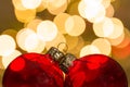 Red baubles against a bokeh of christmaslights Royalty Free Stock Photo