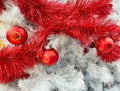 Red baubles with golden ornament on pine tree brenches