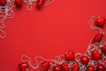 Red baubles and silver beads on the red background with copy space. Top view of various christmas ornaments. Royalty Free Stock Photo