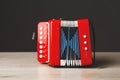 Red bayan toy accordion on gray background