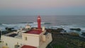 Red beacon placed ocean shore washed by stormy waves drone view. Sea lighthouse Royalty Free Stock Photo