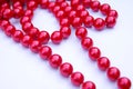 Red beads lie on a white background