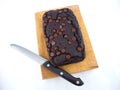 Red bean brownie loaf with chocolate chips on wooden cutting board with knife