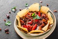 Red bean with nachos or pita chips, pepper and greens on plate over dark background. Mexican snack, Vegetarian food Royalty Free Stock Photo