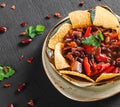 Red bean with nachos or pita chips, pepper and greens on plate over dark background. Mexican snack, Vegetarian food, top view, Royalty Free Stock Photo