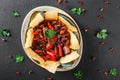 Red bean with nachos or pita chips, pepper and greens on plate over dark background. Mexican snack, Vegetarian food, top view Royalty Free Stock Photo