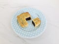 Red Bean Paste moon cake with a portion cutout in a blue spotted round dish on marble background. Aerial view.