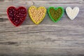 Red beans in red heart shaped  plastic  bowl. White sesame seeds  in white heart shaped. Soybean in yellow heart shaped. Green bea Royalty Free Stock Photo