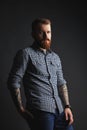 Red bearded man with tattoes studio portrait on dark background