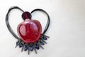 Red beautiful glass transparent bottle of female perfume lying on black string in the shape of a heart decorated with a dragged bl Royalty Free Stock Photo