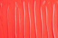 Red beauty cosmetic product, liquid lipstick or lip gloss, paint sample. Abstract art background, red liquid paint. Abstract oil