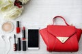 Red beauty stuff on white wooden table with bag