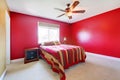 Red bedroom with bed and nighstand. Royalty Free Stock Photo