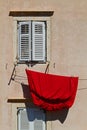Red bedsheet hanging to dry