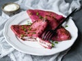 Red beetroot pancakes, pink thin beet crepes stuffed with cream cheese and green onions on gray background. Shrovetide Maslenitsa Royalty Free Stock Photo