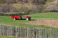 Red behind tractor stands in the farmyard