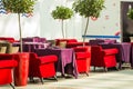 Red and beige armchairs are next to the restaurant tables, which are covered with long burgundy tablecloths