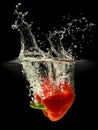 Red bell pepper falling in water with splash on black background Royalty Free Stock Photo