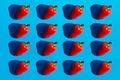 Red bell pepper seamless pattern with dark black deep shadows on blue background flat lay. Minimalistic abstract image. Healthy Royalty Free Stock Photo