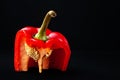 Red bell pepper with seeds. Sliced sweet pepper with pulp on a black background. Organic food. Royalty Free Stock Photo