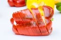 red bell pepper sliced in thin slices on a white background. Royalty Free Stock Photo