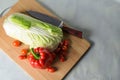 Red bell pepper, tomatoes, Peking cabbage, chopping knife on the board