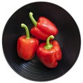 Red Bell Peppers on Black Plate Isolated on White Royalty Free Stock Photo