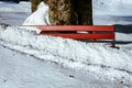 Red bench covered in snow, outdoors during daylight Royalty Free Stock Photo