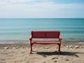 a red bench sitting on a sandy beach next to the ocean Royalty Free Stock Photo