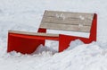 A red bench is sitting in the snow Royalty Free Stock Photo