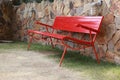 Red bench beside stone wall