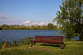 Red bench with a tree by the shore of a lake in spring Royalty Free Stock Photo