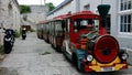 Red Bermuda Train Trolley Parked in Alley at the Royal Naval Dockyard
