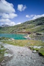 Red Bernina Express train passing along lake in Swiss Alps, Eastern Switzerland. Highest railway track across the Alp