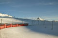 Red Bernina Express train riding through the snow land of Bernina pass Royalty Free Stock Photo