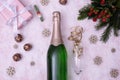 Red berries, bottle of champagne gift lie on a snow-covered table