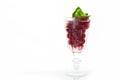 Red berry with basil leaves in a glass glass. Basil leaves. Cherry lemonade in a transparent glass. Refreshing drink